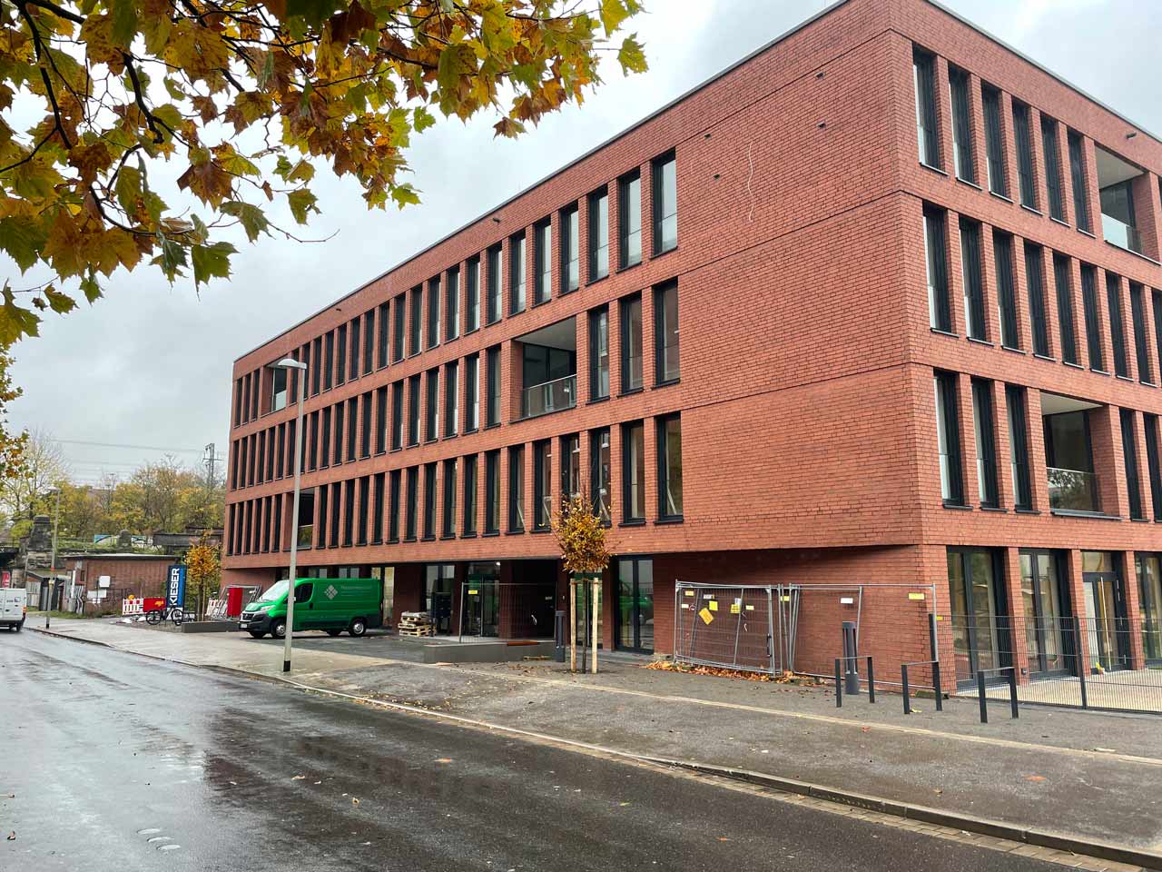 Bürogebäude aus roten Backstein von außen mit Straße davor