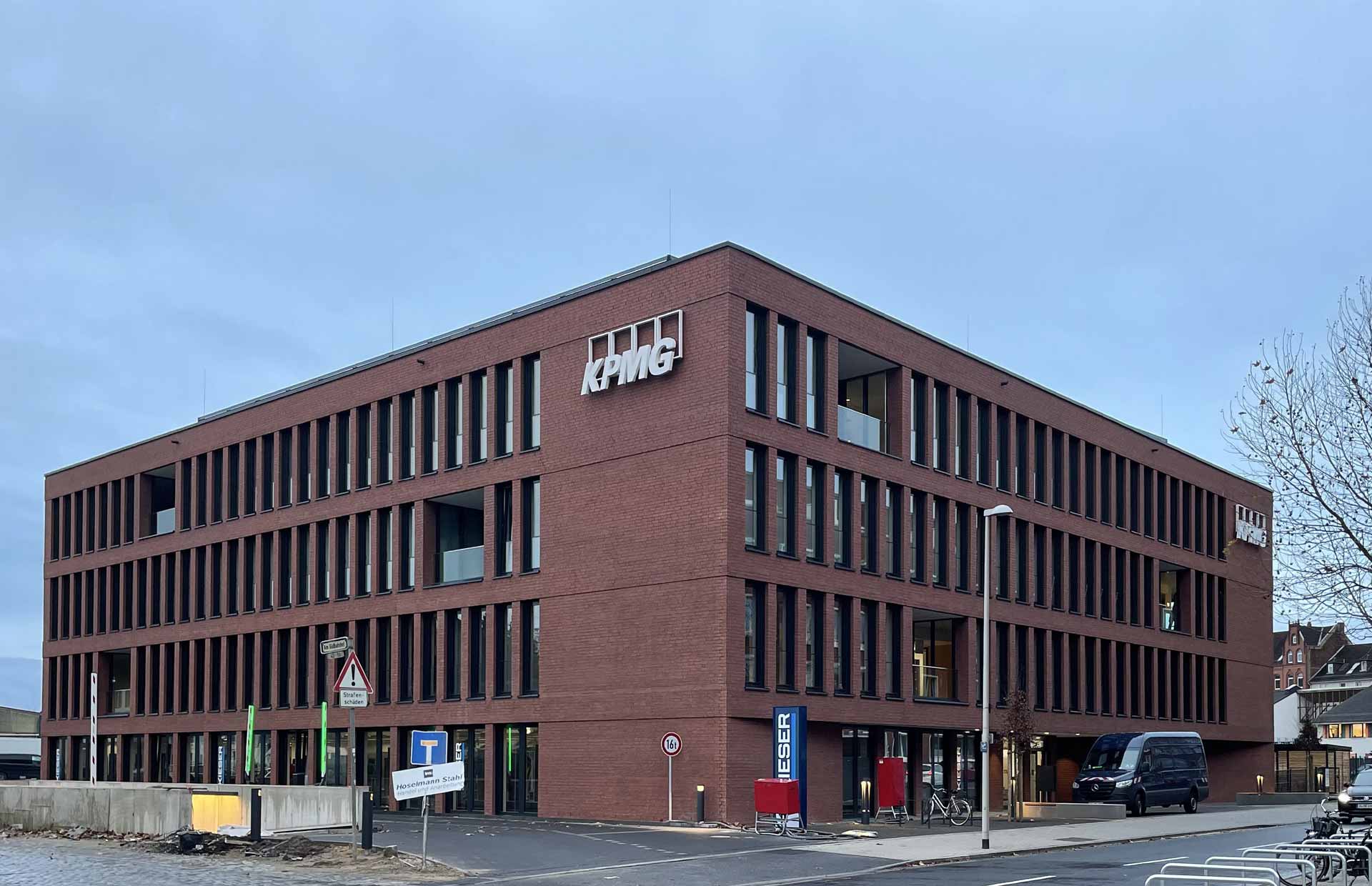 Bürogebäude aus roten Backstein von außen mit Straße davor