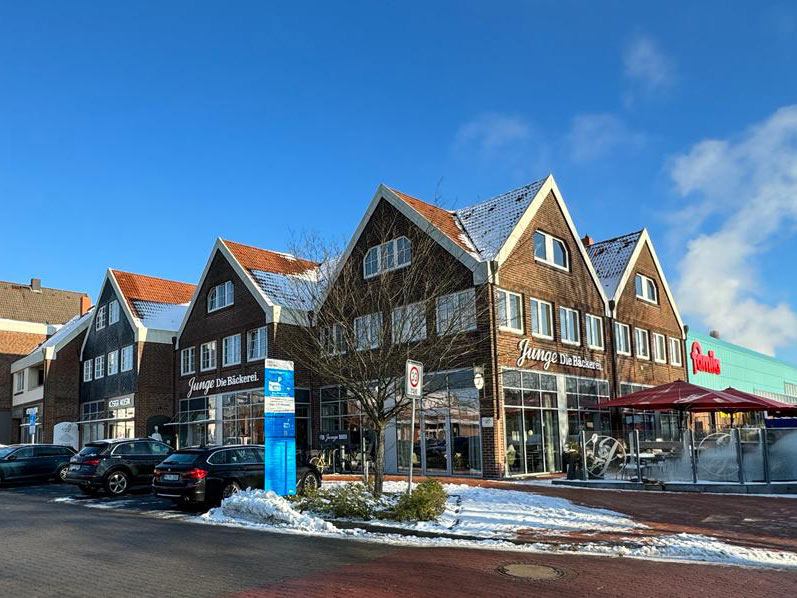 Wohn- und Geschäftshaus im Winter von außen mit Parkplätzen