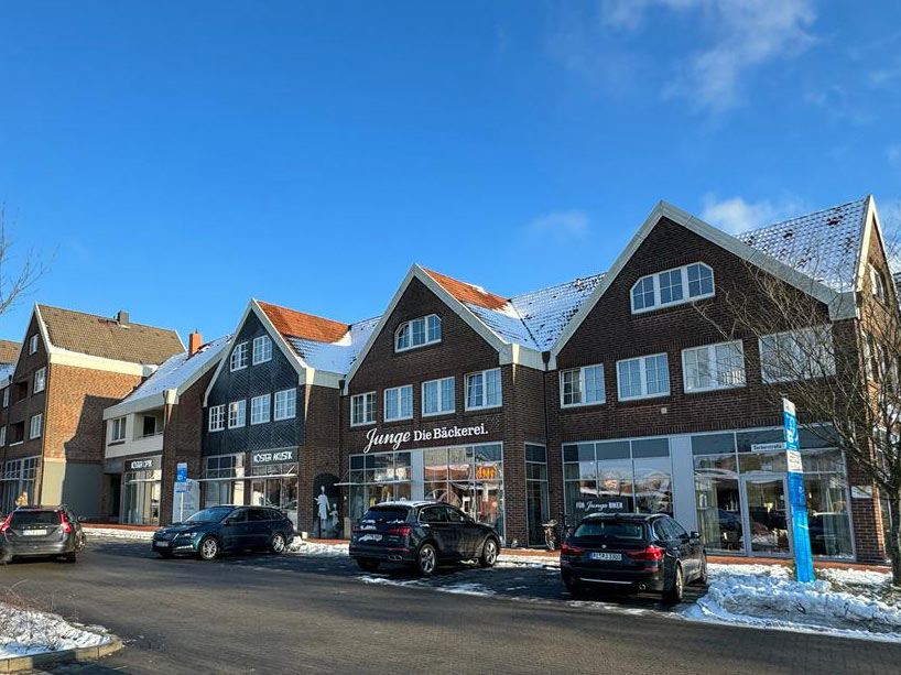 Wohn- und Geschäftshaus im Winter von außen mit Parkplätzen