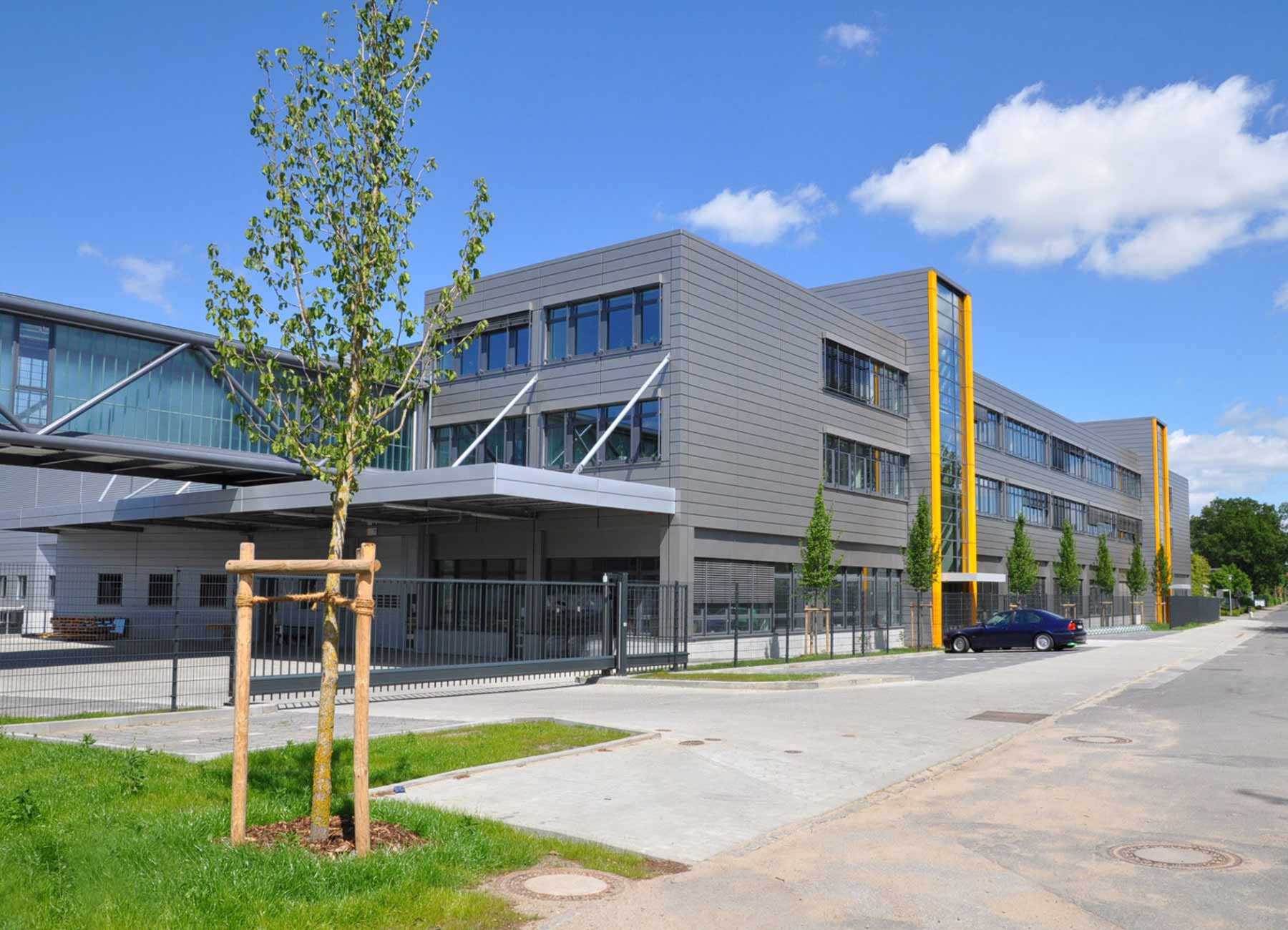 Graues Bürogebäude Außenansicht mit blauen Himmel