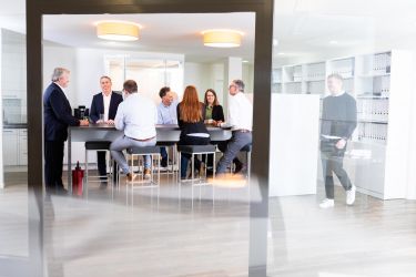 Team sitzt um einen Tisch und redet